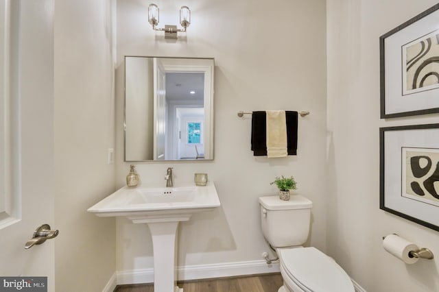 bathroom with hardwood / wood-style floors and toilet