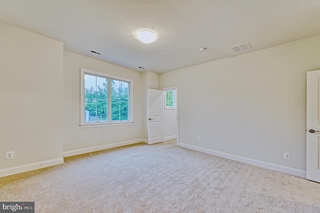 spare room featuring light colored carpet