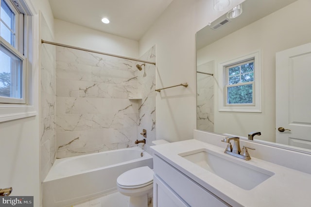 full bathroom with plenty of natural light, vanity, tiled shower / bath combo, and toilet