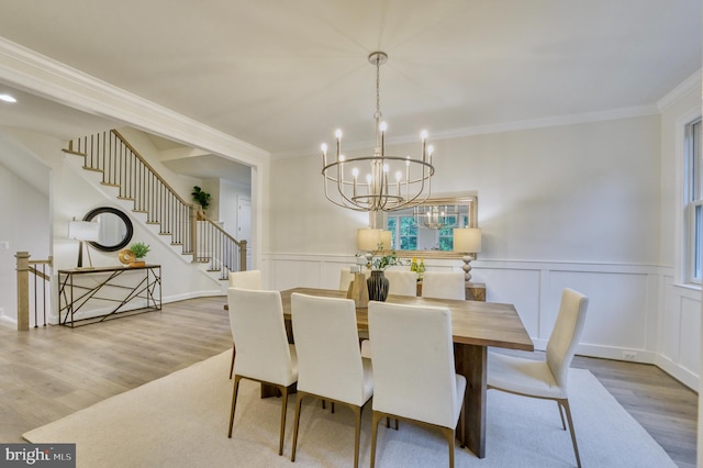 dining space with a chandelier, hardwood / wood-style flooring, and ornamental molding