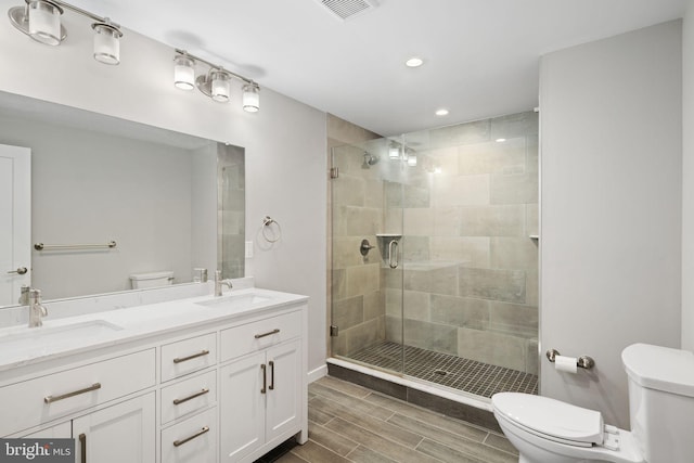 bathroom featuring vanity, toilet, and an enclosed shower