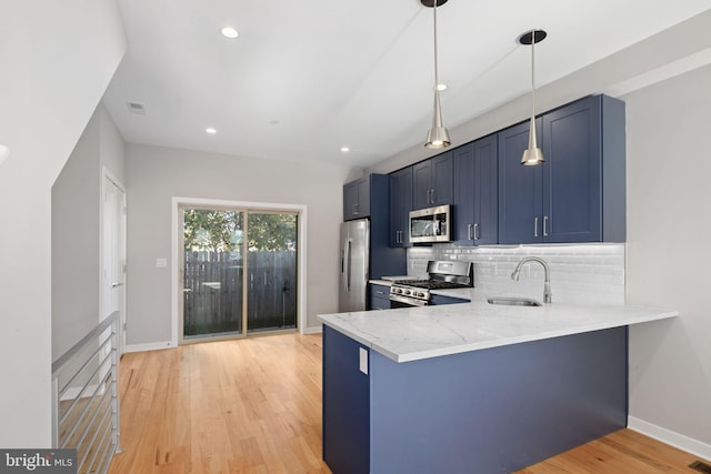 kitchen with kitchen peninsula, stainless steel appliances, light hardwood / wood-style flooring, and sink