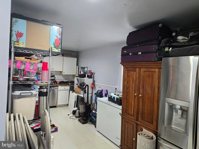 interior space featuring white cabinets, stainless steel fridge, and white fridge