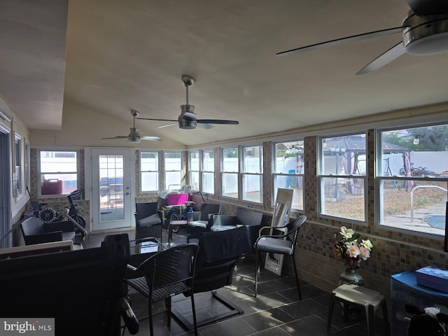 sunroom / solarium with ceiling fan, a wealth of natural light, and vaulted ceiling