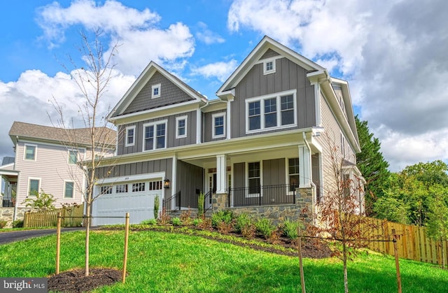 craftsman house featuring a porch, a garage, and a front lawn