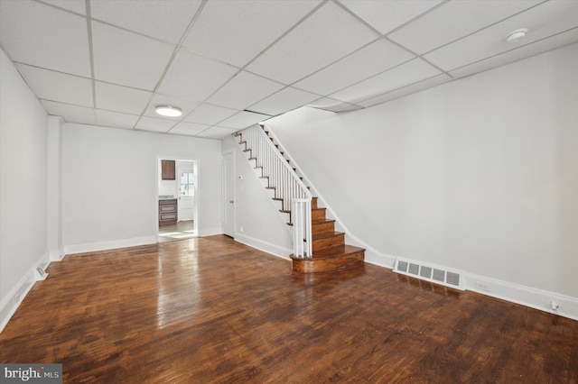 basement featuring a paneled ceiling and wood-type flooring