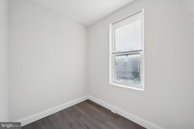 unfurnished room with dark hardwood / wood-style flooring