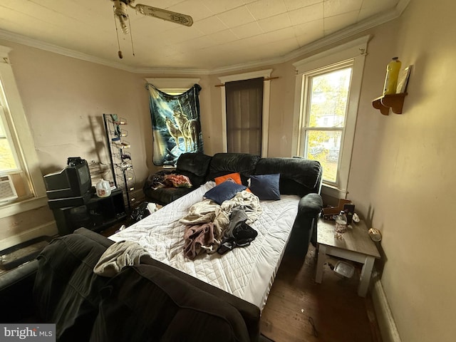 bedroom with hardwood / wood-style flooring, ceiling fan, and ornamental molding