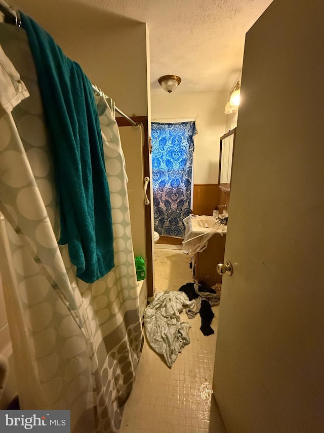 bathroom with a textured ceiling and walk in shower