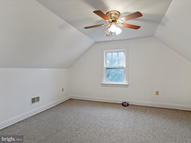 additional living space featuring a textured ceiling, ceiling fan, carpet, and vaulted ceiling