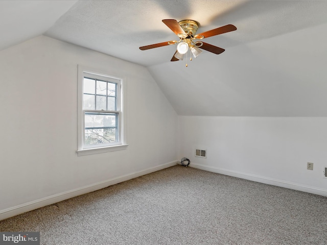 bonus room with carpet, a textured ceiling, ceiling fan, and lofted ceiling