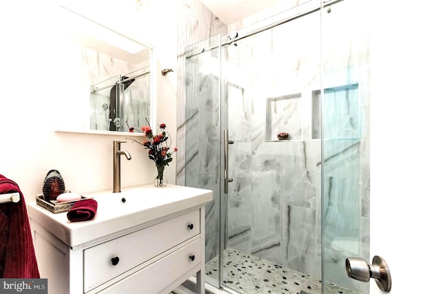 bathroom with a shower with door and vanity