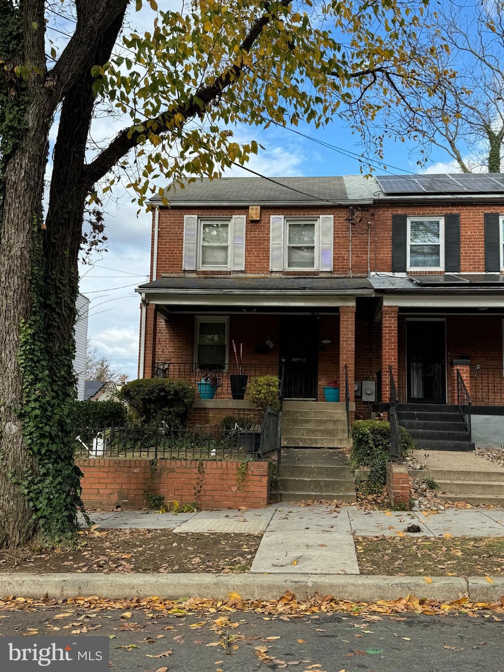 view of property with covered porch and solar panels