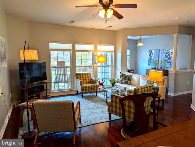 living room with dark hardwood / wood-style floors, ceiling fan, and decorative columns