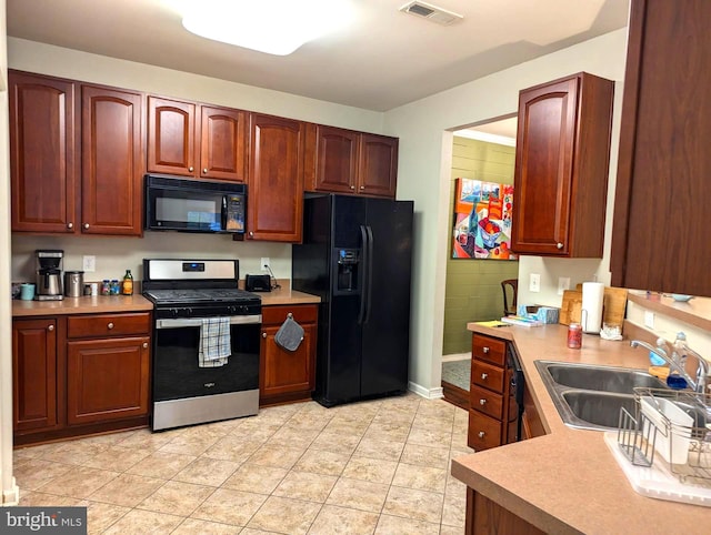 kitchen with sink, light tile patterned flooring, and black appliances