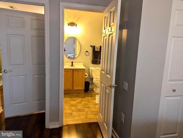 bathroom featuring vanity, toilet, and wood-type flooring