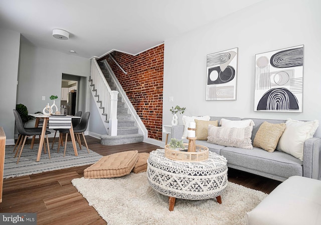 living room featuring dark hardwood / wood-style floors and brick wall