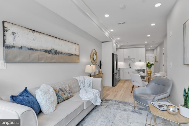 living room featuring light hardwood / wood-style flooring and sink