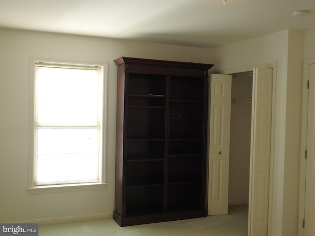 unfurnished bedroom with light colored carpet and multiple windows