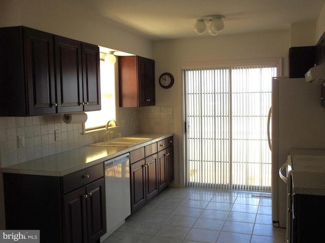 kitchen with dishwasher, light tile patterned floors, sink, and a wealth of natural light