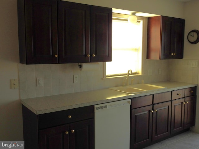 kitchen featuring tasteful backsplash, dishwasher, light tile patterned floors, and sink