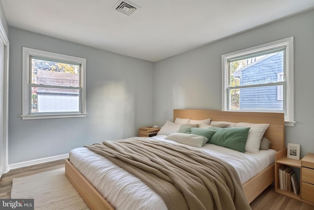 bedroom featuring wood-type flooring and multiple windows