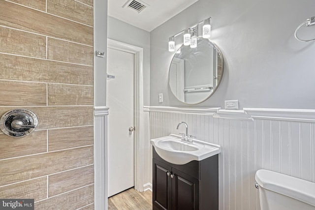 bathroom with toilet, vanity, and hardwood / wood-style flooring