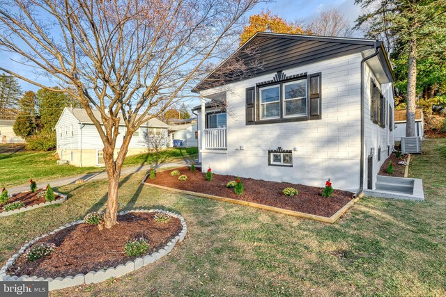 view of front facade with central AC unit and a front yard