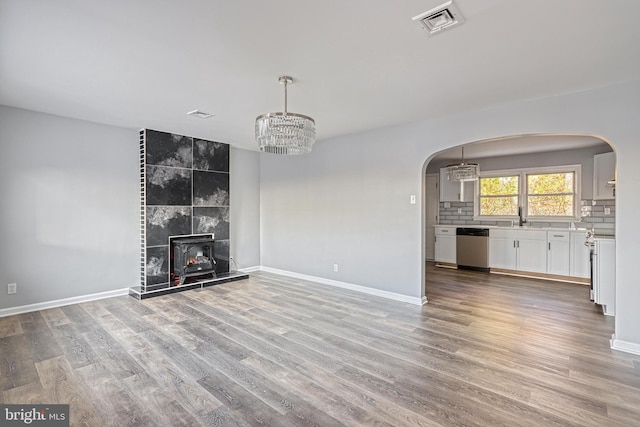 unfurnished living room with hardwood / wood-style flooring, sink, and a chandelier