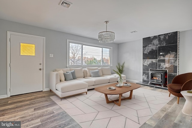 living room featuring a wood stove, hardwood / wood-style floors, and a chandelier