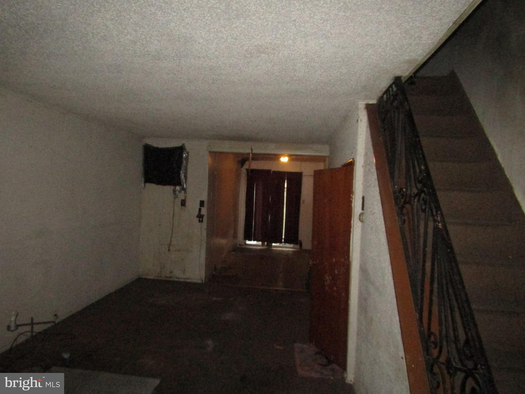 hall featuring a textured ceiling