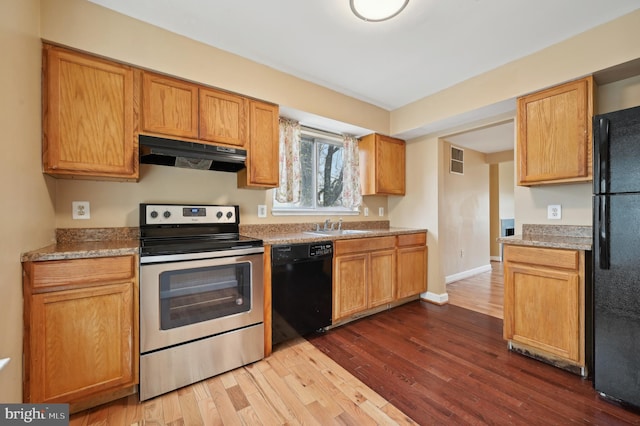 kitchen featuring dark wood-type flooring, black appliances, and sink