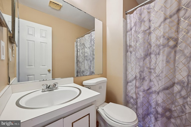 bathroom featuring vanity, toilet, and walk in shower