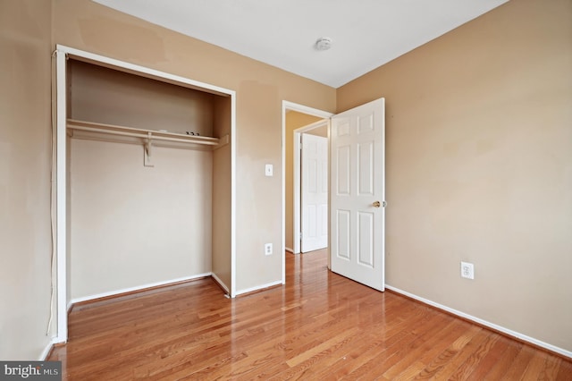 unfurnished bedroom with a closet and light hardwood / wood-style floors