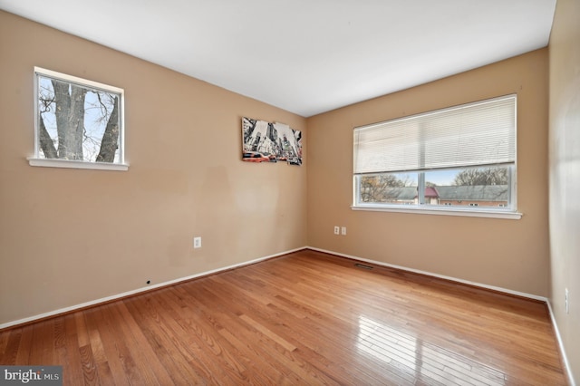 unfurnished room featuring light hardwood / wood-style flooring and a healthy amount of sunlight