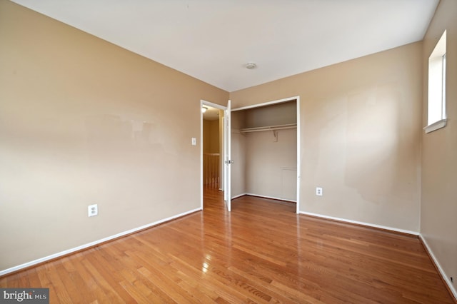 unfurnished bedroom featuring wood-type flooring and a closet