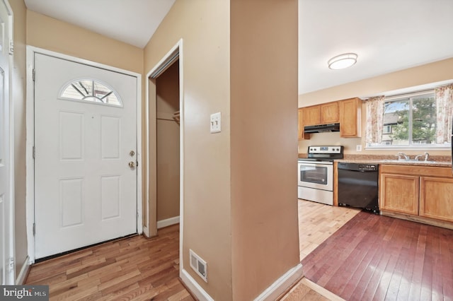 kitchen featuring sink, light hardwood / wood-style flooring, stainless steel range with electric stovetop, and black dishwasher