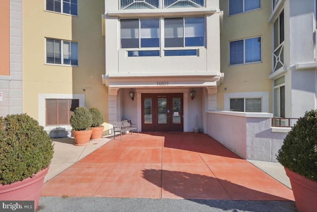 view of exterior entry with a patio and french doors