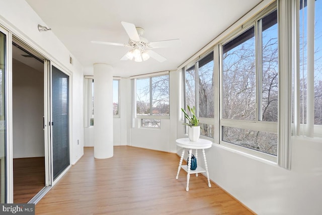 unfurnished sunroom with ceiling fan