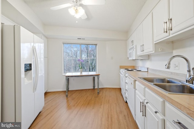 kitchen featuring white cabinetry, sink, ceiling fan, light hardwood / wood-style floors, and white appliances