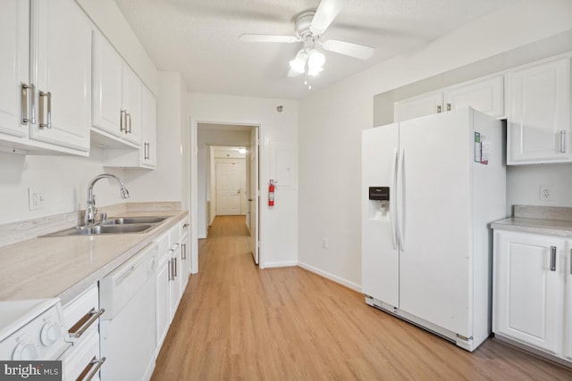 kitchen with white appliances, white cabinets, sink, ceiling fan, and light hardwood / wood-style floors