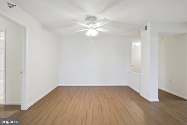 unfurnished room with ceiling fan, wood-type flooring, and a textured ceiling