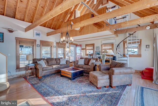 living room featuring high vaulted ceiling, an inviting chandelier, an AC wall unit, hardwood / wood-style flooring, and beam ceiling