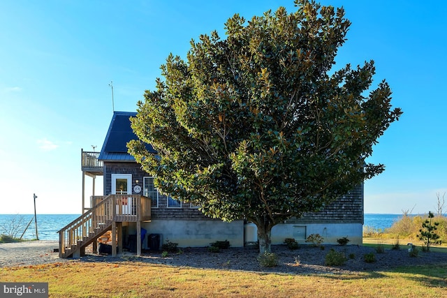 view of side of property with a lawn and a water view