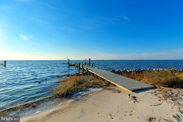 dock area featuring a water view and a beach view