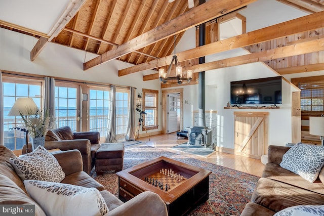 living room with beam ceiling, hardwood / wood-style floors, a chandelier, and plenty of natural light