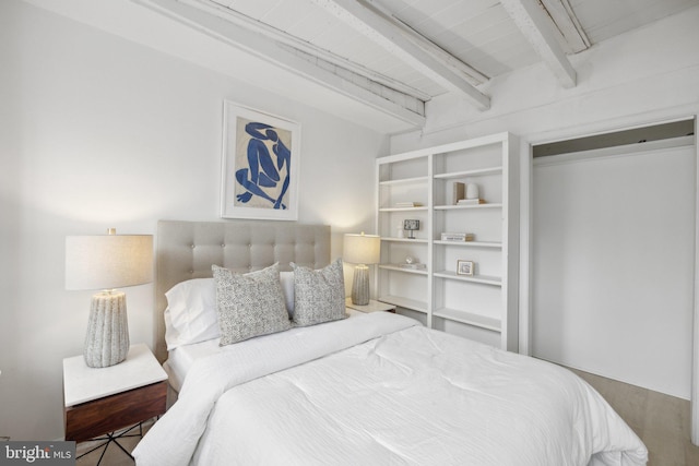 bedroom with beam ceiling and a closet