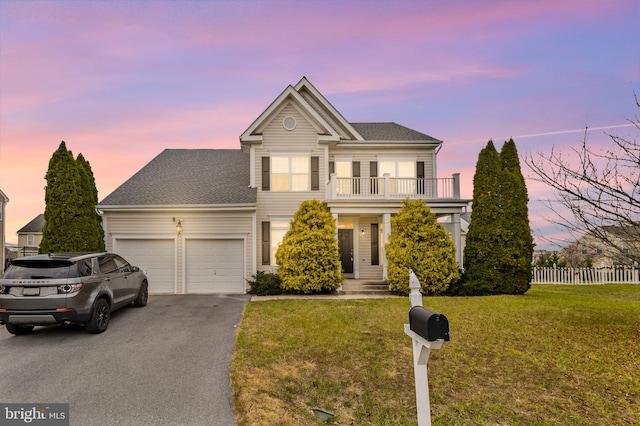 view of front of home featuring a lawn, a garage, and a balcony