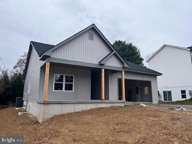 view of front facade with a garage, central AC unit, and covered porch