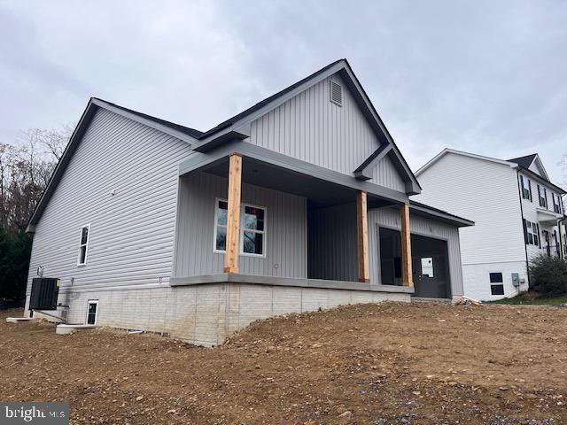 rear view of property with central AC unit and covered porch